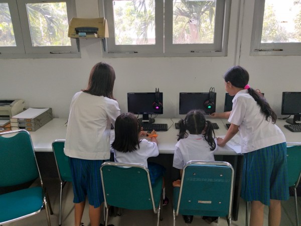 Kakak kelas menjelaskan cara menyalakan  komputer