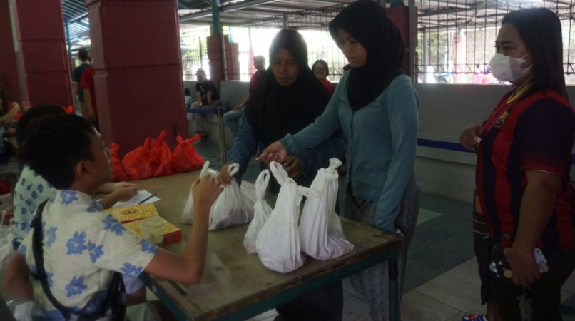 Penyerahan daging kurban kepada warga sekitar sekolah