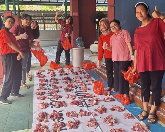 Ibu-ibu guru bertugas mengukur dan membungkus daging